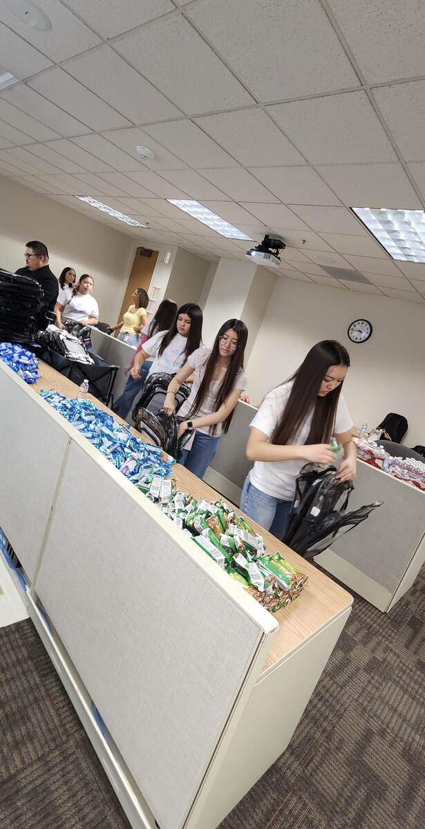 Youth volunteers packing supplies into backpacks