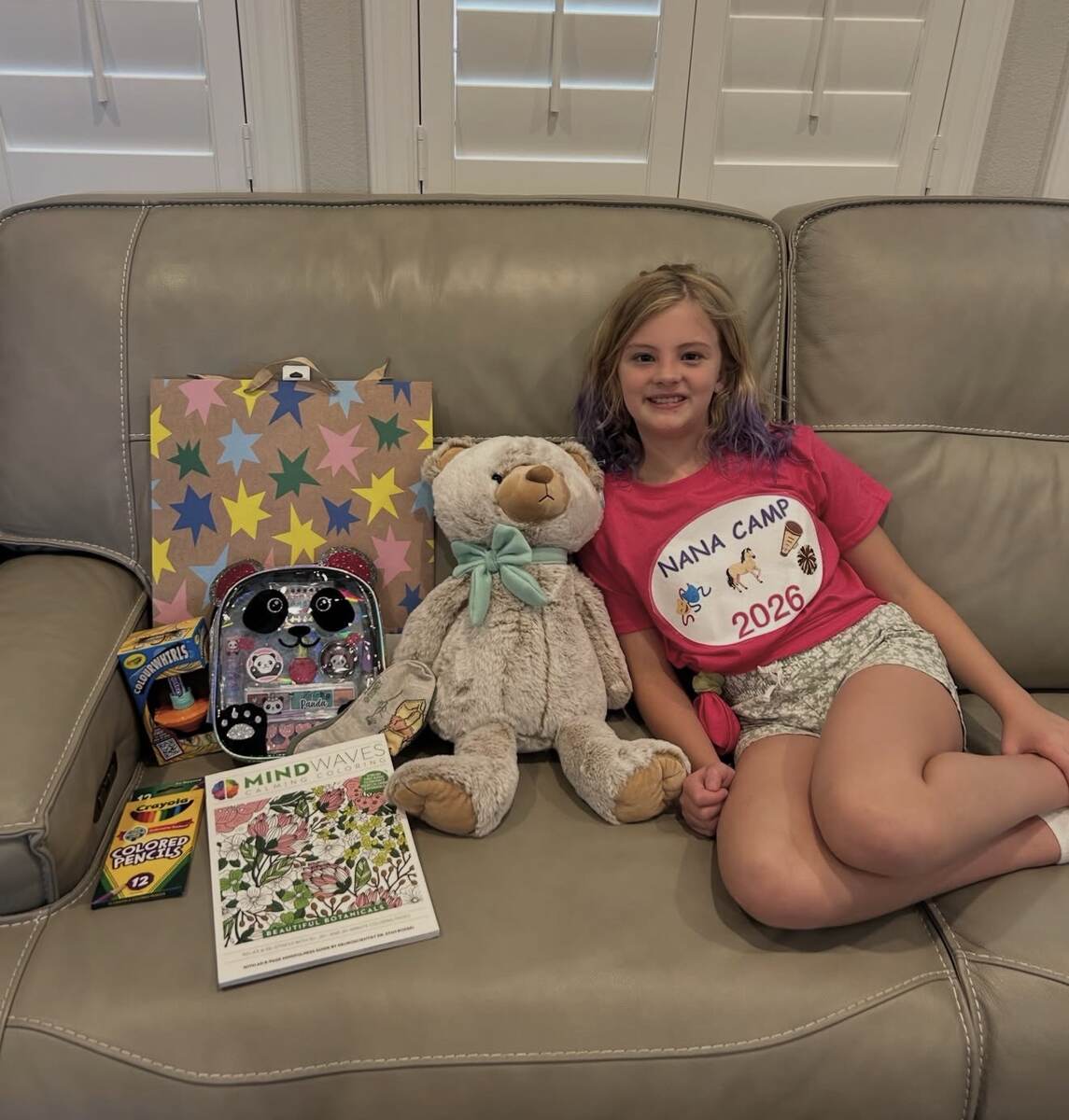 Child surrounded by personalized birthday gifts
