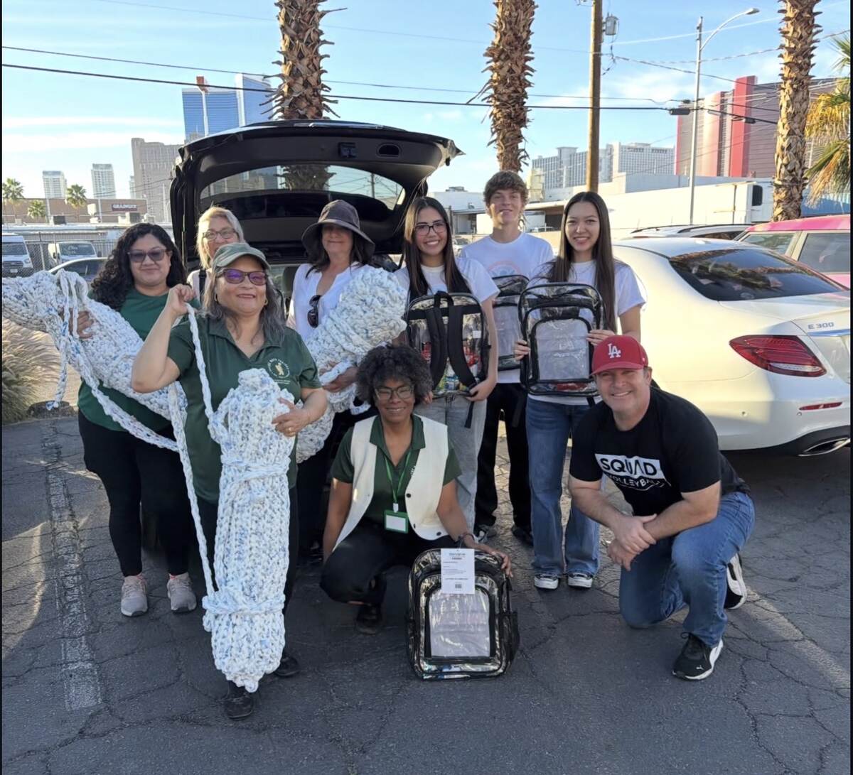 Volunteers holding handmade sleeping mats and filled backpacks