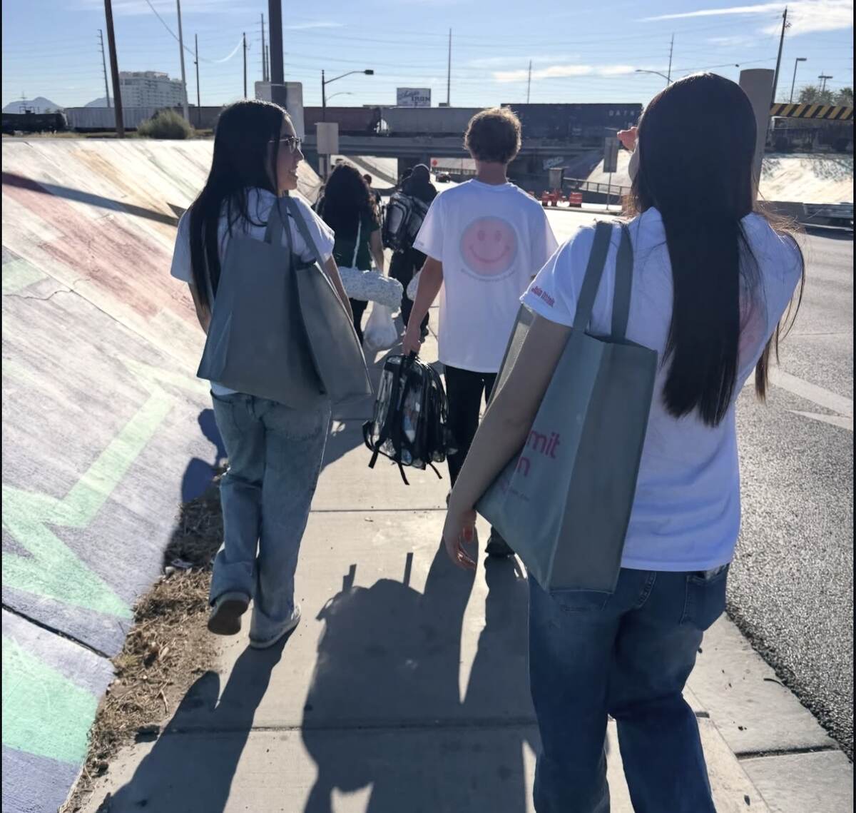 Youth volunteers carrying outreach bags through downtown Las Vegas