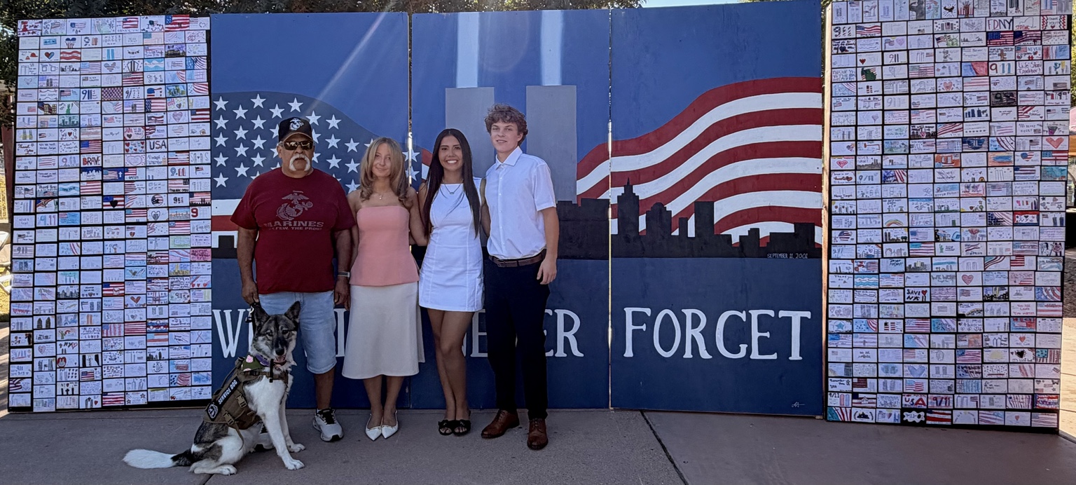 Aiyana Castro and youth with a veteran and service dog beside the youth-created 9/11 Remembrance Wall